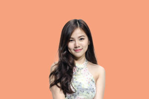 Asian woman smiling with dimple long hair black eyes on orange background