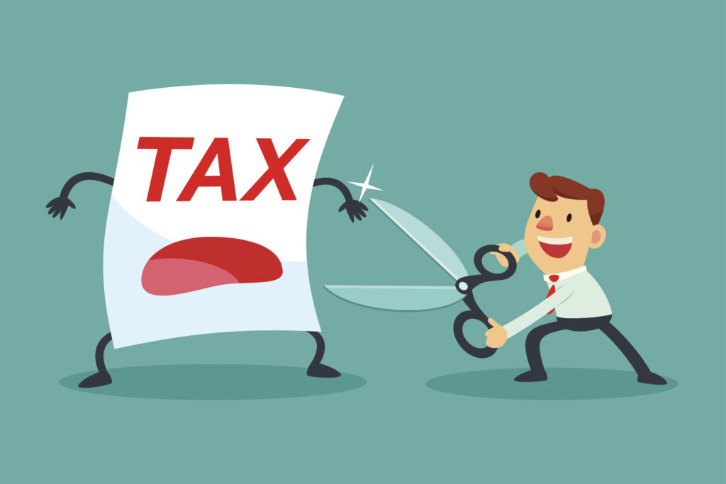 businessman holding big scissors about to cut tax paper