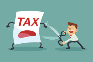 businessman holding big scissors about to cut tax paper